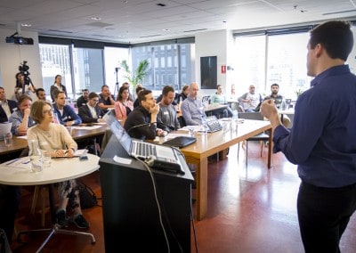 Business presenter addressing an engaged audience at a workshop or seminar in a modern office meeting room